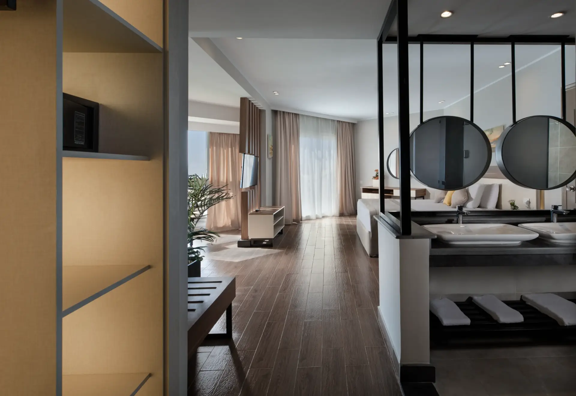 Junior Suite at V Grand Sahl Hasheesh with open double vanity, round mirrors, wardrobe with safe and view through to the bedroom