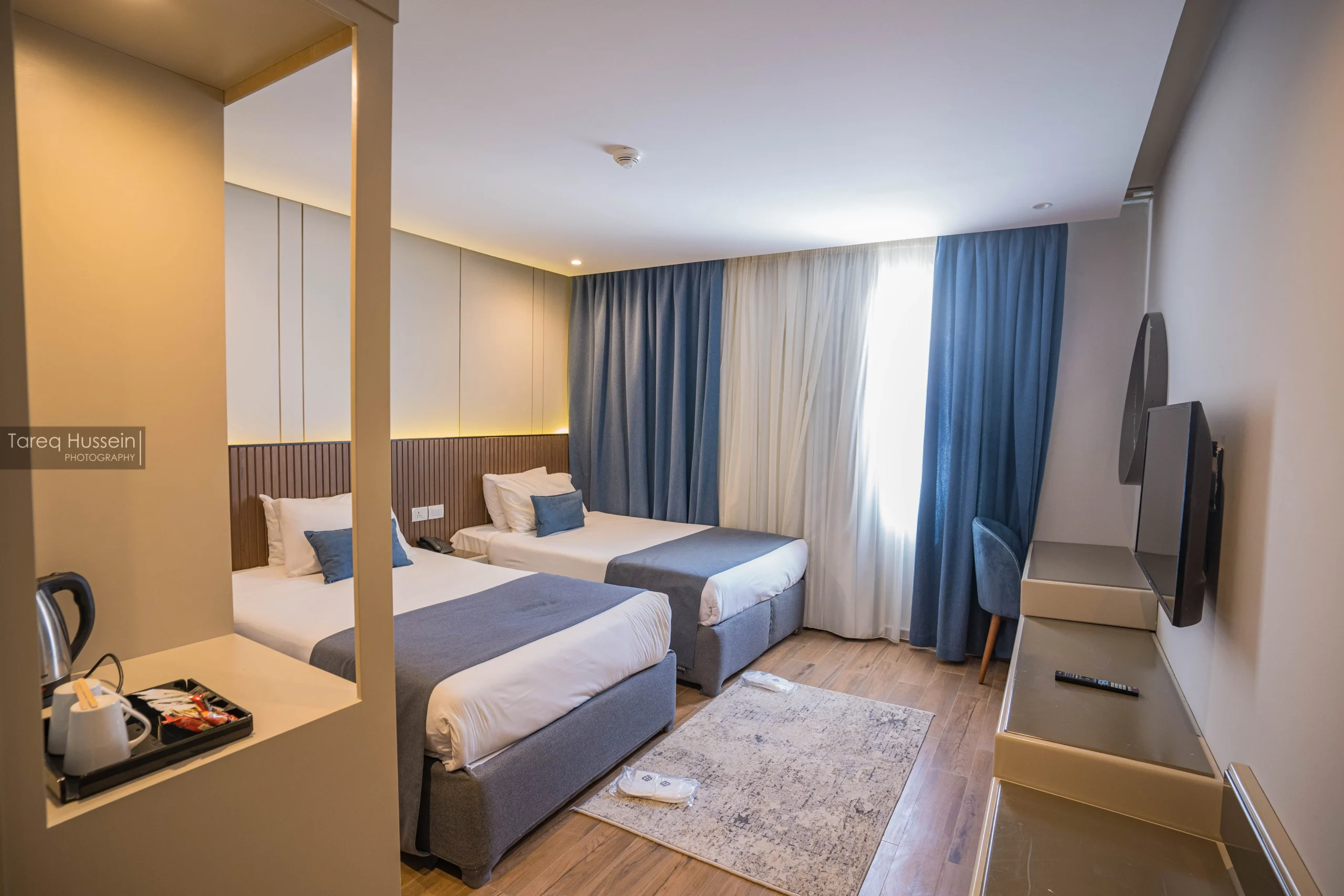 Second bedroom of the Master Suite at V Grand Sahl Hasheesh with twin beds, blue curtains and tea and coffee station