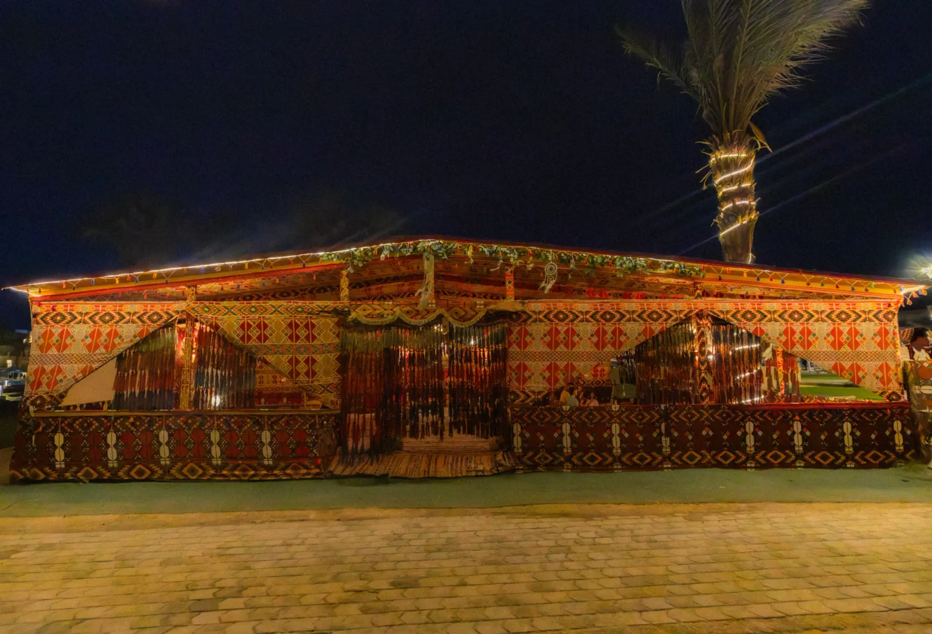 Bedouin Tent Café at V Grand Sahl Hasheesh at night, decorated with colourful woven textiles, tassels and lights